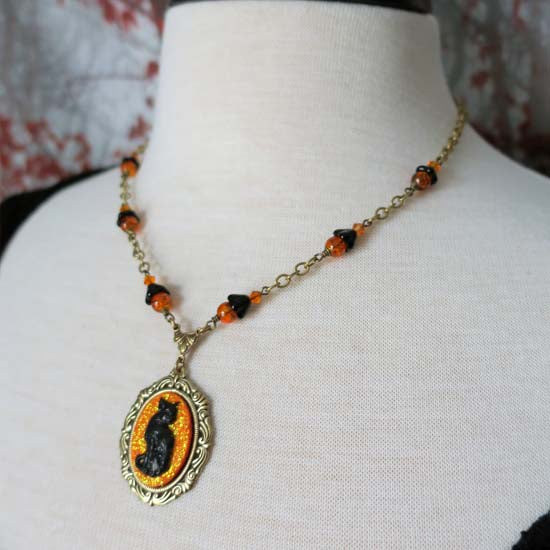 Black Cat Necklace - small with orange glitter - antique brass